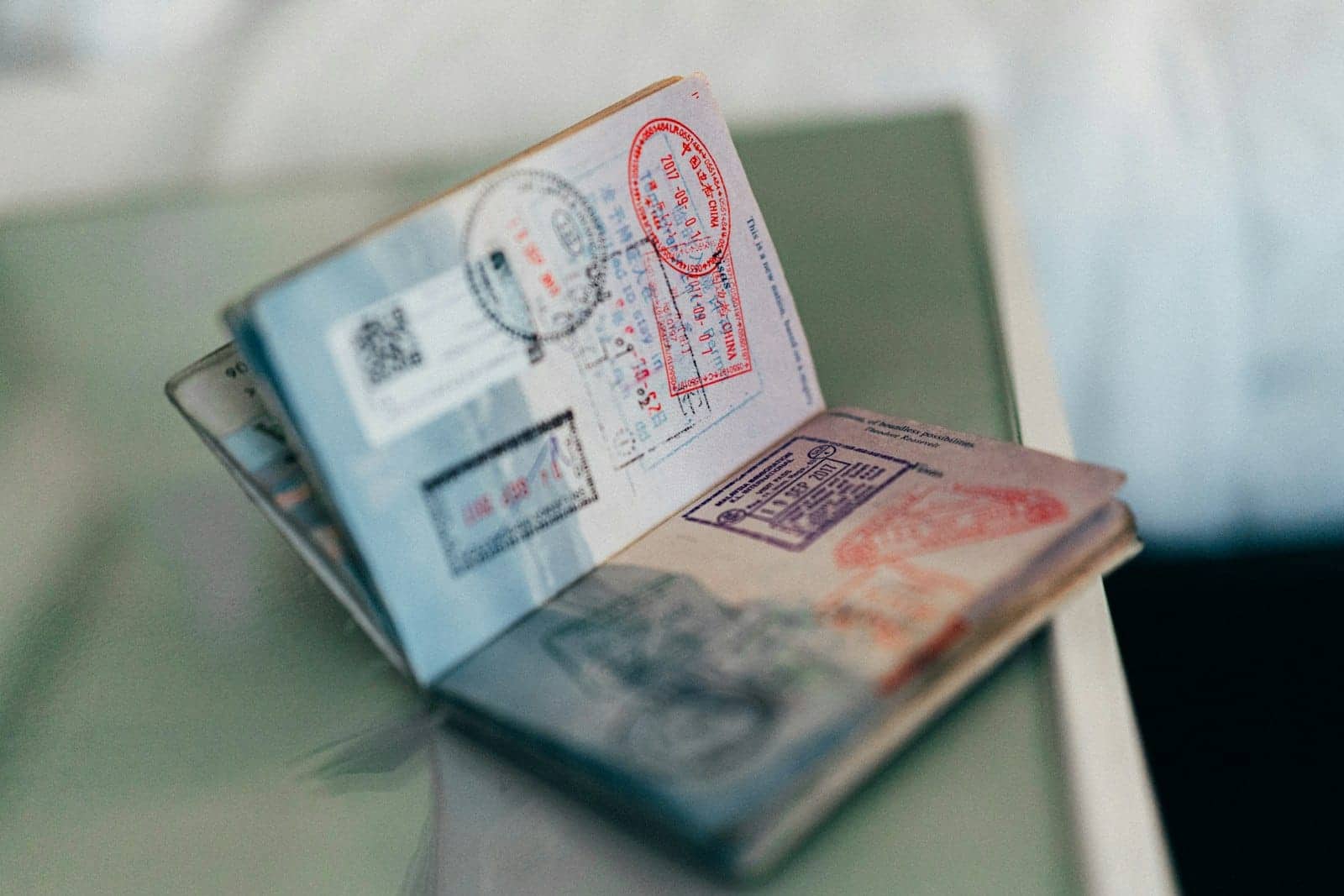 Раскрытый загранпаспорт с разноцветными въездными штампами на столе